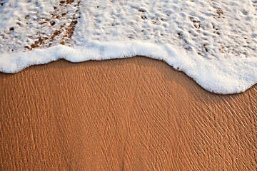 Wave surging on sand on beach