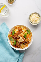Top view of italian pasta bolognese in white bowl cheese basil