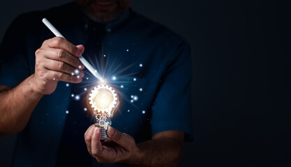 Businessman holding illuminated light bulb. Inspiration of ideas for sustainable business...