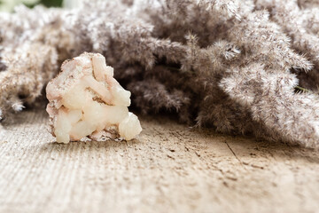Raw Stilbite crystal sample on wood with copyspace