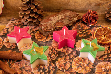 Sternkerzen in rot und grün. Mit weihnachtlicher Dekoration