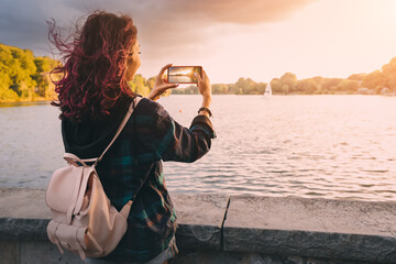 Travel blogger takes photos on the camera of smartphone of the Aasee lake in Munster, Germany