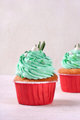 Christmas cupcake with green icing decorated with sugar sprinkles in red cup. Serving size dessert...