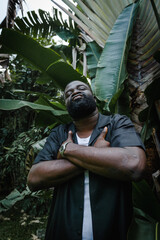 A man between palm trees posing for a portrait