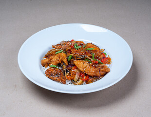 Asian cuisine. Close-up of white plate of rice and herb spicy fried chicken.