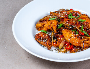 Asian cuisine. Close-up of white plate of rice and herb spicy fried chicken.