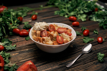 spoon and vegetable salad with crackers on the table .