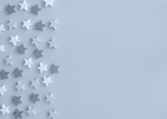 Flatlay with White and Light Blue Wooden Stars Sprinkled on a Light Baby Blue Background. Funny Starry Party Layout. Carnival Composition. No text. Top-Bottom View. Frame Made of Stars.