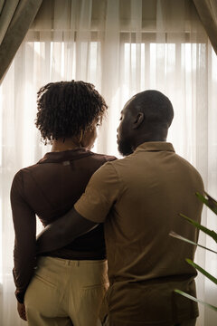black couple looking out a window together