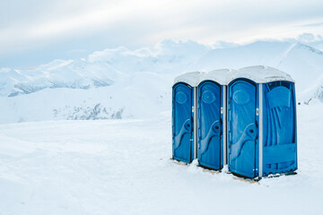 Portable three blue toilets for skiers ski resort clients on top of mountain in Gudauri winter ski...