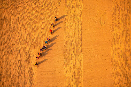 Aerial view of farmers working in a field drying rice on a rice field in Dhamrai, Dhaka, Bangladesh.