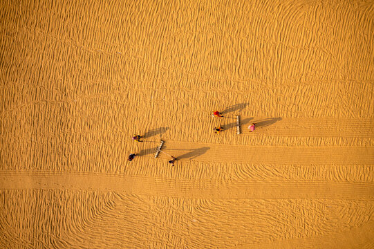 Aerial view of farmers working in a field drying rice on a rice field in Dhamrai, Dhaka, Bangladesh.