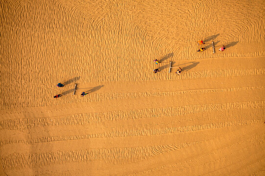 Aerial view of farmers working in a field drying rice on a rice field in Dhamrai, Dhaka, Bangladesh.