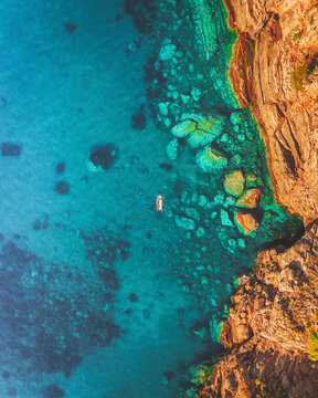 Aerial view of a boat on the western coast of Mallorca, Cala Estellencs, Spain.