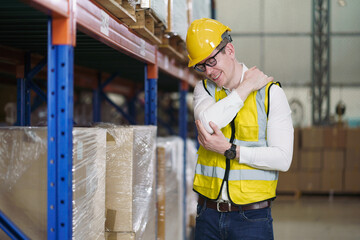 Back ache concept of factory worker. Young man looking painful expression. Portrait of young male feeling pain while touching shoulder and his back by hand. Man suffering from office syndrome.