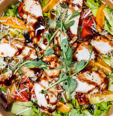 Sliced ​​pieces of fried chicken, teriyaki sauce and fresh salad. Top view, close-up