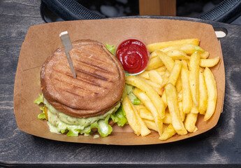 Close-up of fresh tasty food. Burger, fries and cetchup in cardboard box. Fast food. Top view.