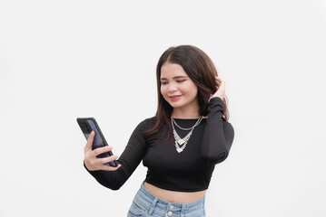 Naklejka premium A studio shot of a beautiful vlogger recording her day using her cellphone. Isolated on a plain white backdrop.