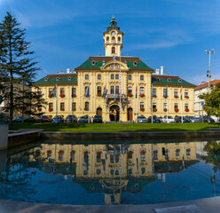 view of the Szeged city hall building with reflections in a fountain pool