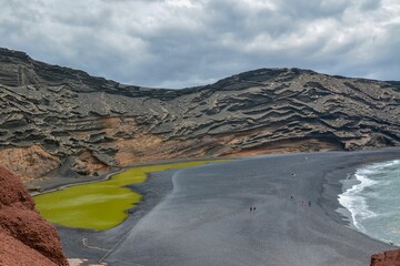 Aerial view of the green lagoon at the beach on a cloudy day in El Golfo © Iain Mcculloch/Wirestock Creators