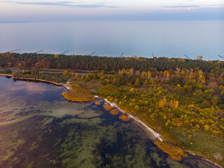 Fototapeta na wymiar drone view of a colourful autumn sunset over the hel peninsula, the baltic sea and the gulf of puck; colourful autumn leaves on the trees