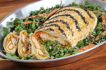 Salmon Wellington with Carrots and Vegetables on a Bed of Greens