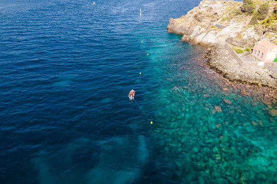 Aerial view of a fishing boat along the coast in Aci Trezza, Sicily, Italy.