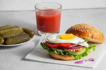 healthy breakfast of a hamburger with vegetables and scrambled eggs served with salted pickled...