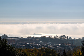 Fototapeta na wymiar Fog clouds over the sea with a ship