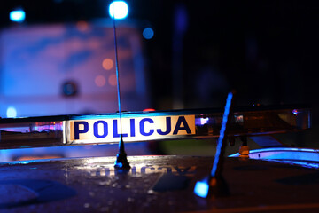 Akcja nocna  alarmowa policji - Sygnalizator błyskowy niebieski na dachu radiowozu policji polskiej w nocy. Światła policyjne. - obrazy, fototapety, plakaty