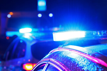 Akcja nocna  alarmowa policji - Sygnalizator błyskowy niebieski na dachu radiowozu policji polskiej w nocy. Światła policyjne. - obrazy, fototapety, plakaty