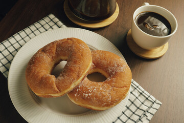 Freshly made donuts on the breakfast table with black coffee - 541787691