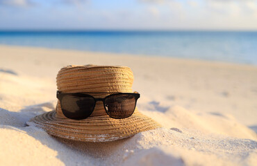 Holiday and Relaxation - Sunglasses and a hat at the Beach.