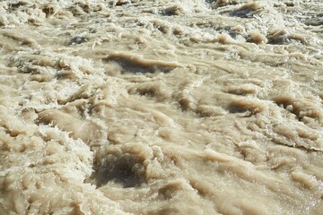 A swift mountain river. Water flows in nature. Mountainous terrain.