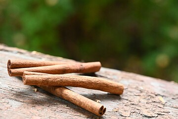 cinnamon sticks on a wooden surface on a green natural background. the concept of healthy food, diet