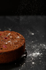 Tasty delicious homemade chocolate cake on dark black background. Space for text