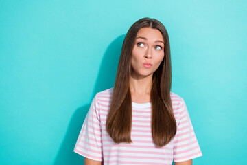 Photo of thoughtful minded girl with long hairstyle wear striped t-shirt dreaming look empty space isolated on turquoise color background