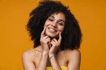 Portrait of young beautiful smiling curly woman pushing her cheeks