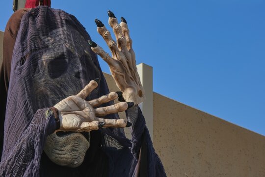Spooky skull in black veil and crossed bone hands welcomes guests on halloween party. Halloween outside decorations. 