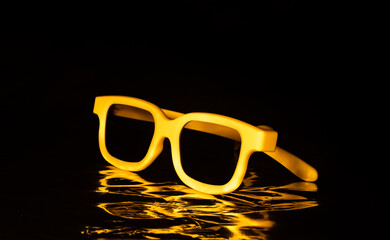 yellow plastic glasses on a black background