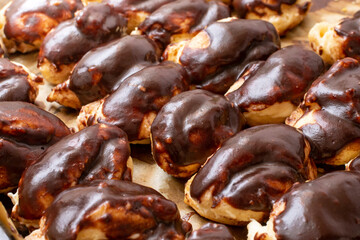 Many home made eclairs covered with chocolate,