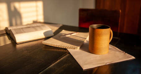 study table with chair long shadow, mug textbook and a notepad