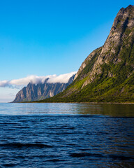 landscape of the island of senja in northern norway, mighty mountains and cliffs above the sea, fjords with breathtaking views