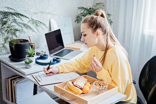 Flexible working, flexible work. Young woman freelancer working at home office with laptop and documents. Flexible work schedule.