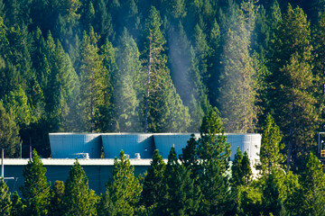 Geothermal electricity power plant on forested, hillside