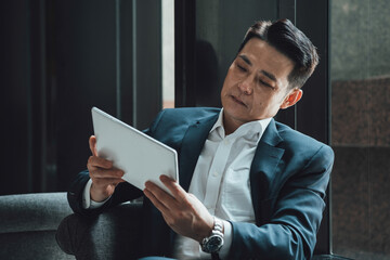 Serious Businessman Using Digital Tablet In Coffee Shop