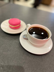 Cup of coffee and pink macaroon
