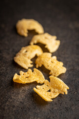 Halloween crispy bat shaped chips on dark table.