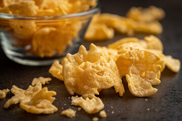 Halloween crispy bat shaped chips on dark table.