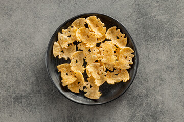 Halloween crispy bat shaped chips on plate. Top view.